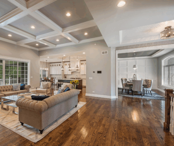 Interior view of a modern living room with coffered ceiling and adjacent dining area.